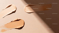 Varied shades of creamy foundation makeup on beige background