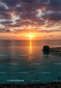 Beautiful Sunset Over Calm Ocean with Pier and Cloudy Sky