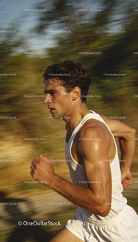 Focused Male Athlete Running Outdoors in Warm Light