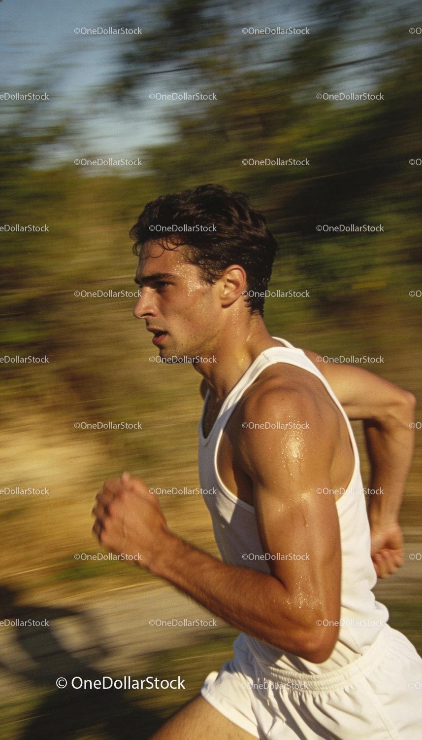 Focused Male Athlete Running Outdoors in Warm Light