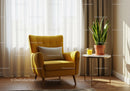 Cozy yellow armchair with indoor plant and juice