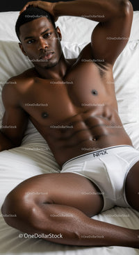 Athletic man relaxing in white underwear on bed