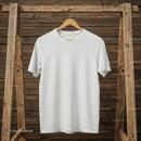 Plain white t-shirt hanging on rustic wooden rack