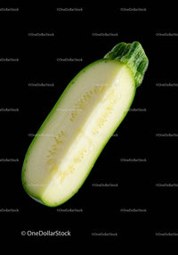 Fresh green zucchini half isolated on black background