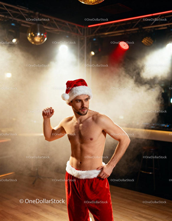 Shirtless man wearing Santa costume dancing indoors