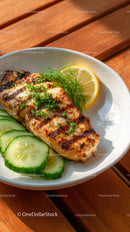 Grilled Fish with Lemon and Fresh Cucumber on White Plate