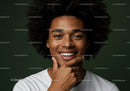 Portrait of Smiling Woman with Afro Hair and Freckles Against Green Background