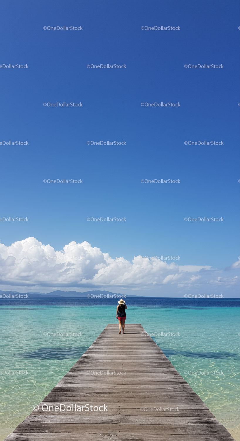 Woman Walking on Pier Over Clear Blue Water Under Bright Sky