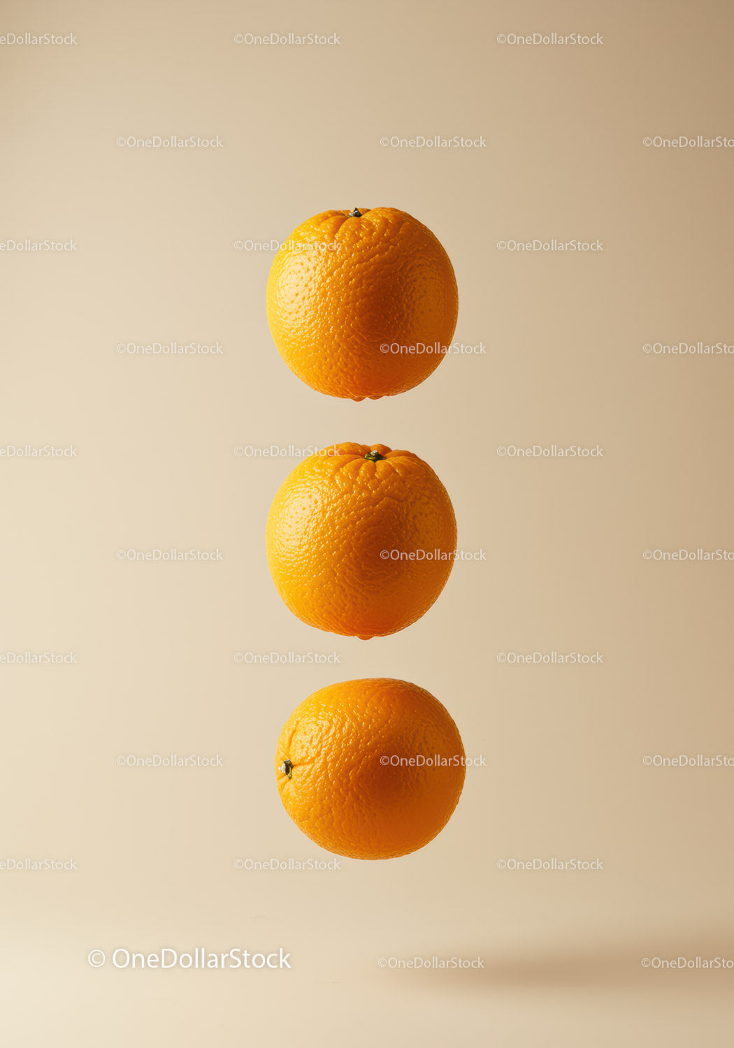 Three Fresh Oranges Floating on Light Beige Background