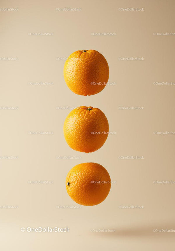 Three Fresh Oranges Floating on Light Beige Background