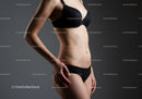 Elegant Woman in Black Lingerie Standing in Studio with Gray Background