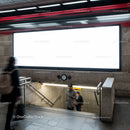 Commuters walking in urban subway station with blank billboard