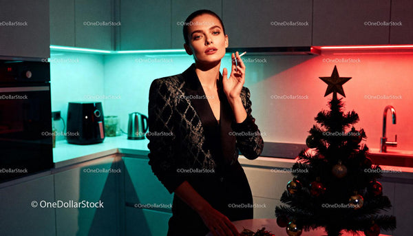 Elegant woman smoking in modern kitchen with Christmas tree