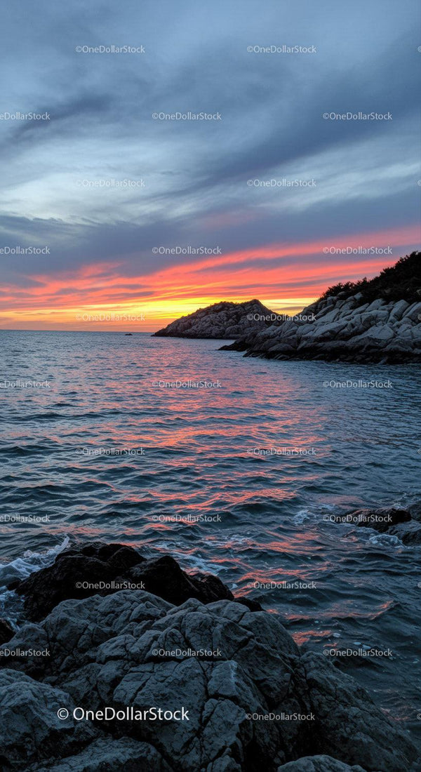 Colorful Sunset Over Rocky Coastline with Vibrant Sky