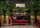 Elegant living room with red velvet chaise lounge and plants