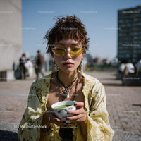 Stylish Young Woman with Short Curly Hair and Yellow Sunglasses Outdoor