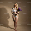 Elegant Tattooed Woman in White Lingerie Holding Purple Flowers