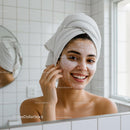 Smiling woman with facial mask and eye patches in bathroom