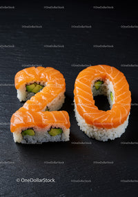 Salmon sushi shaped as number twenty on black surface