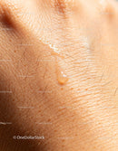 Close-up of skin with drop of skincare serum