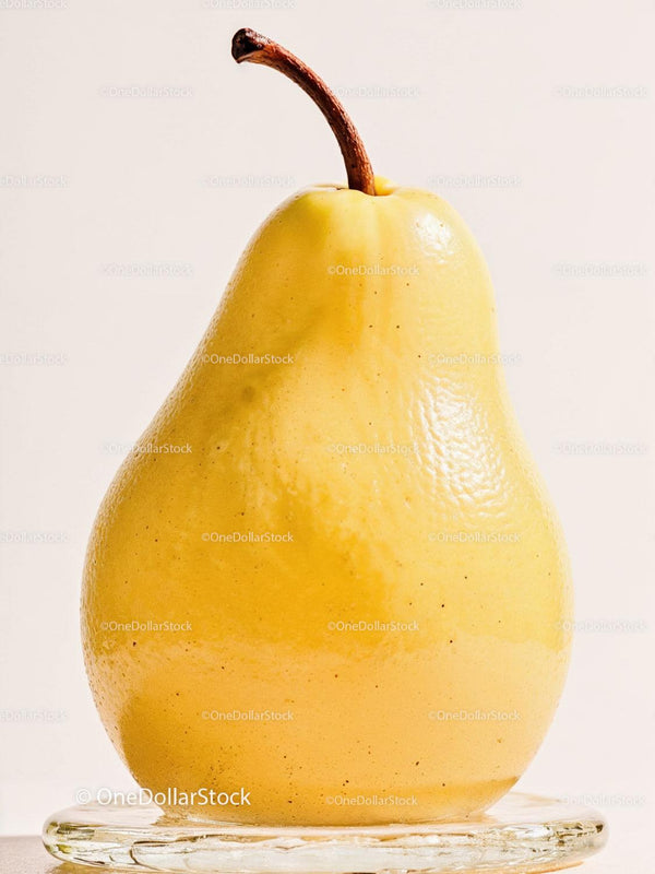 Fresh yellow pear with water droplets on glass plate