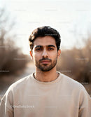 Confident young man in casual beige sweatshirt outdoors