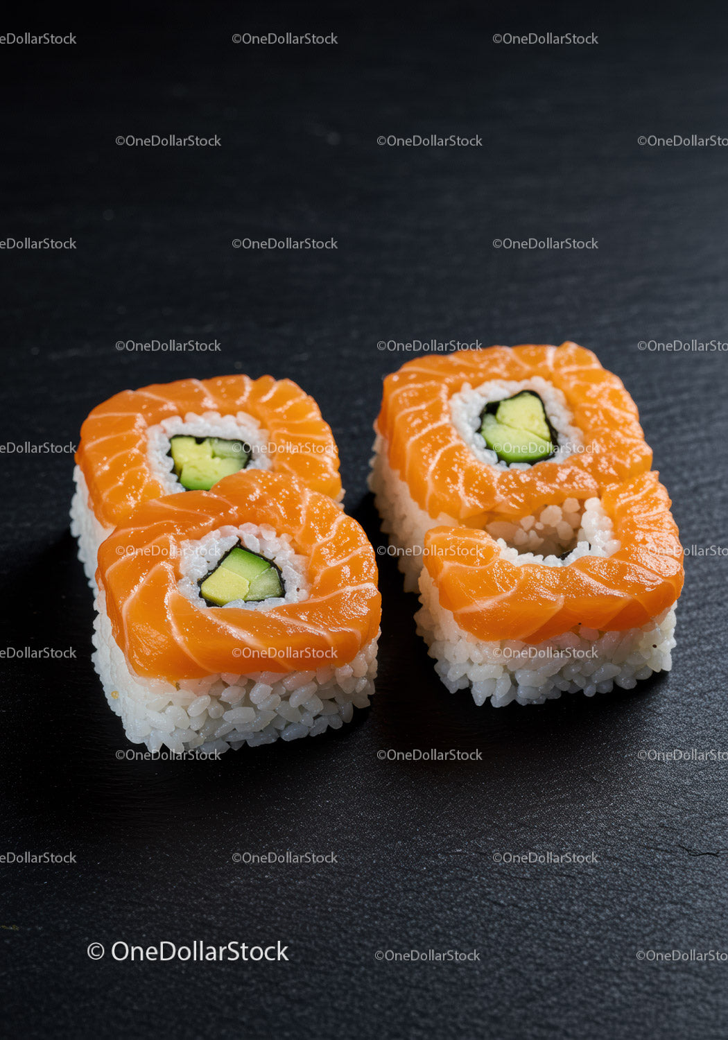 Świeże rolki sushi z łososiem i awokado na czarnym talerzu