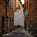 Narrow European street with hanging laundry and white cloth