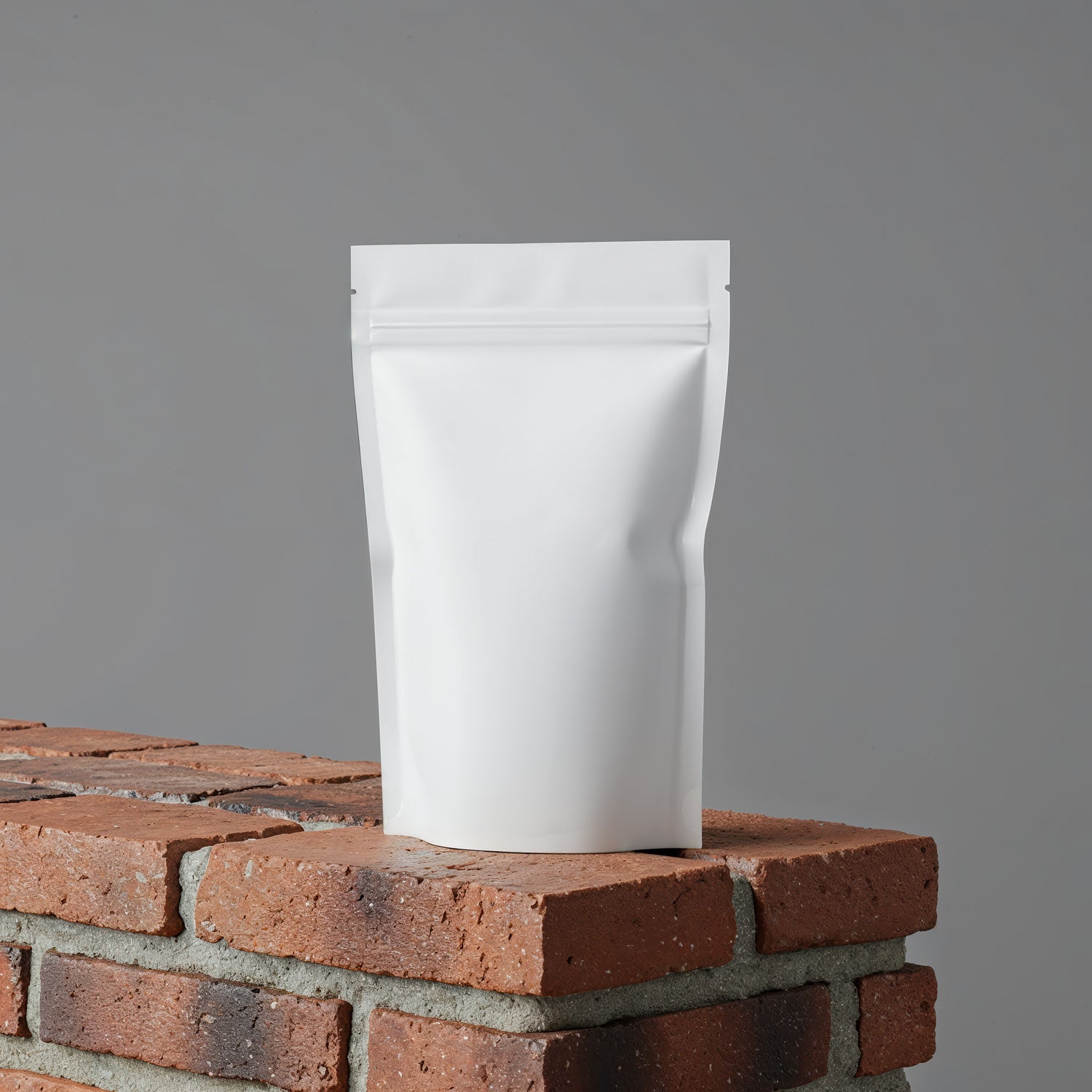 Minimalist white pouch standing on red brick surface