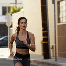 Focused young woman running outdoors in urban setting