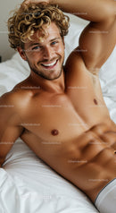 Smiling young man relaxing on white bed at home