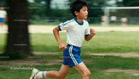 Young boy running outdoors in sporty attire