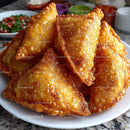 Crispy Golden Samosas on White Plate with Side Dishes