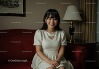 Young Woman Smiling Sitting on Red Sofa in Cozy Living Room