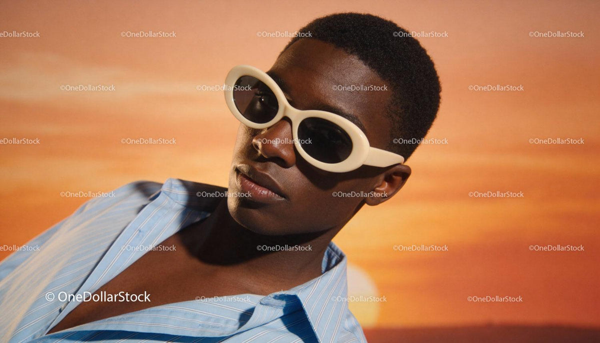 Stylish young man wearing white sunglasses at sunset
