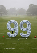 Golf course with number ninety nine made from balls