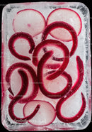 Radish slices frozen inside a clear ice block