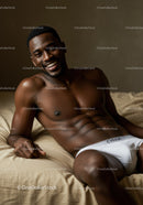 Smiling young man relaxing on bed in white underwear