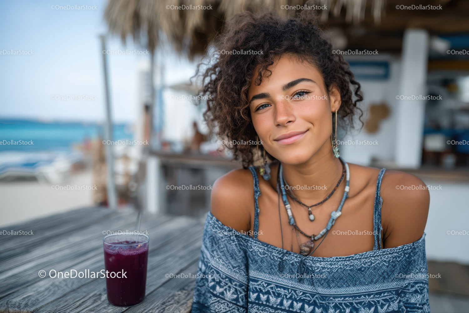 Portret uśmiechniętej młodej kobiety relaksującej się w kawiarni przy plaży