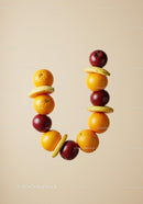 Balanced stack of fresh mixed fruits on beige background
