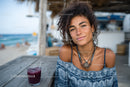 Young Woman Smiling at Beachside Cafe with Ocean View