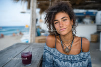 Young Woman Smiling at Beachside Cafe with Ocean View