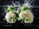 Fresh White Cauliflower with Green Leaves Under Water Splash