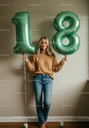 Young woman celebrating eighteenth birthday with balloons