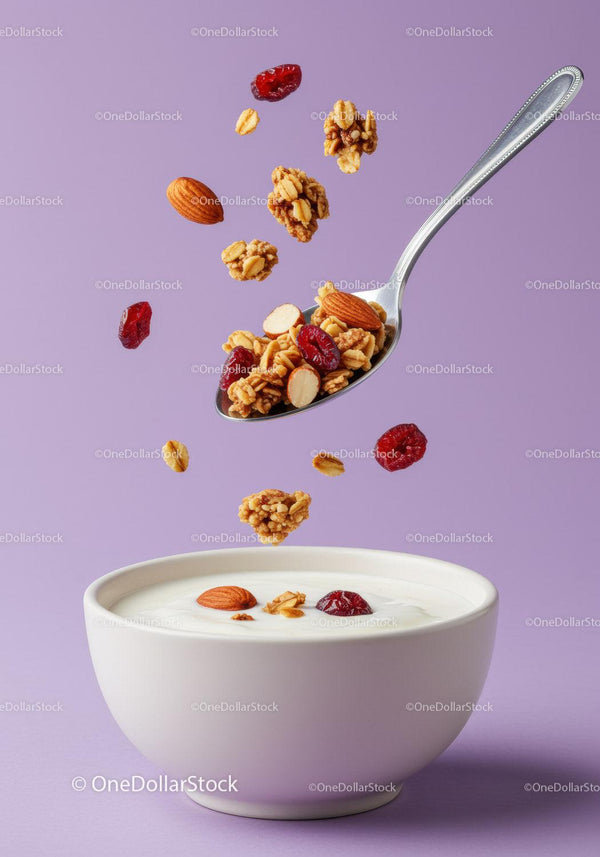 Crunchy granola and nuts falling into yogurt bowl