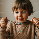Little child playing with colorful sprinkles indoors