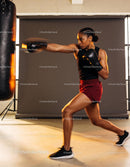 Focused woman boxing with punching bag in gym workout
