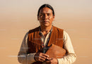 Portrait of a Native American Man with Traditional Attire in Sunny Desert Setting