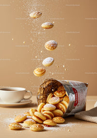 Mini pancakes spilling from bag with powdered sugar dust