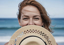 Smiling Woman with Straw Hat by the Ocean in Summer Vacation Scene